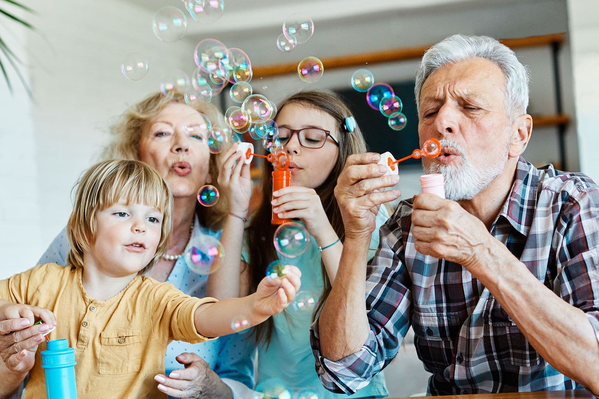 Grandparents blow bubbles with their grandchildren.