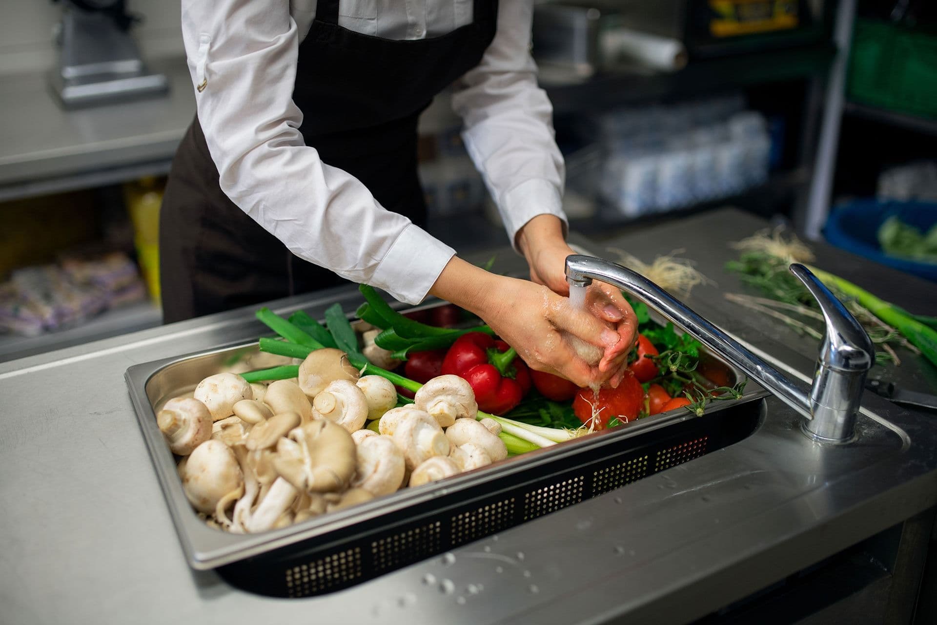 close up of cook washing vegetables